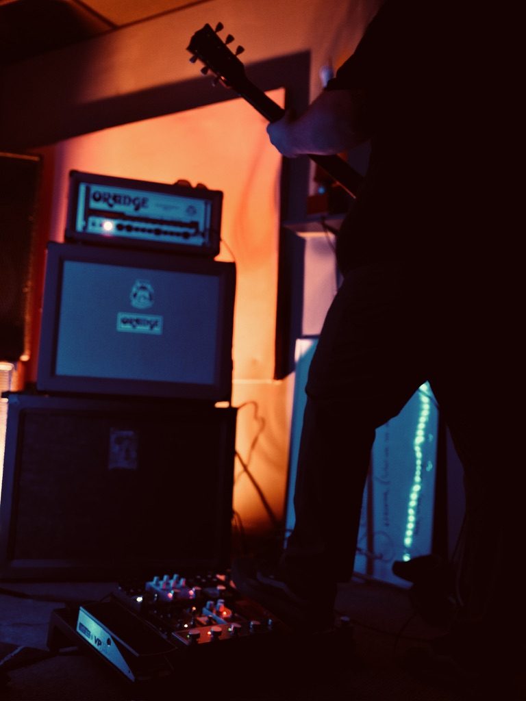 The TOSA guitarist performing with Orange amp stack